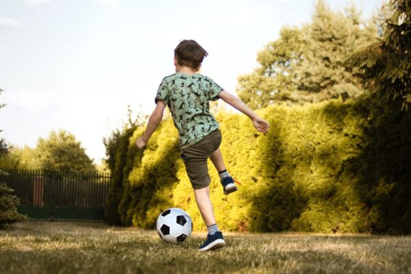 chłopiec gra w piłkę nożną